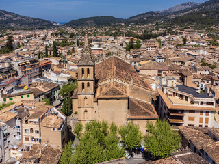 Aerial view of the village with parish of Sant Bartomeu in the foreground and the mountains of the...