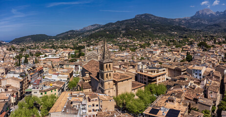 Aerial view of the village with parish of Sant Bartomeu in the foreground and the mountains of the...
