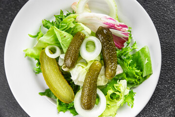 Pickle salad gherkins pickled cucumbers mixed green leaf lettuce appetizer vegetables dish organic fresh tasty gourmet food background on the table food top view copy space vegetarian vegan food