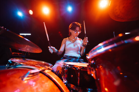 Female drummer performing live on stage with drum kit - Powered by Adobe