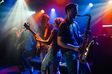 Music band playing live on stage with colorful lights