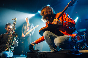Guitarist picking up guitar strap during live rock concert