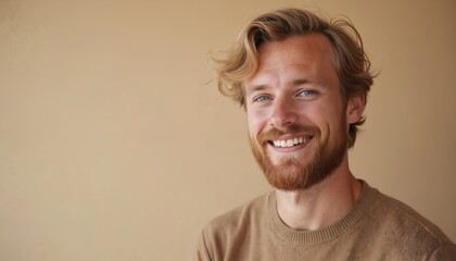 Portrait of smiling Scandinavian man with blond hair against solid beige background. Middle-aged male model with beard. Happy person with positive emotion, casual attire. Studio shot with copy space.