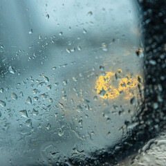 Snow and rain on car mirror - car lights in background