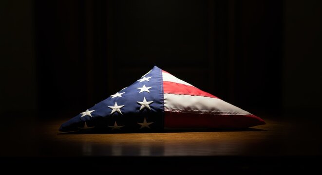 American flag draped in triangular shape on dark background  