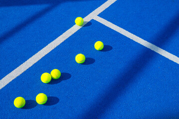 racquet sport background, seven padel balls on blue paddle tennis court concept