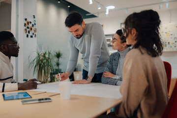 Creative team discussing project strategy during meeting in modern office