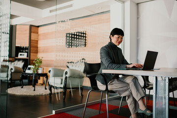 Businesswoman working on laptop in modern office