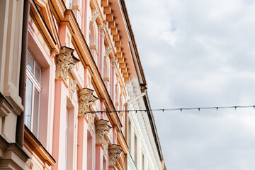 A charming European street lined with pastel-colored historic buildings, ornate architectural details, and a nostalgic atmosphere under a soft daylight sky