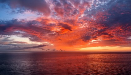 vibrant red and orange clouds suspended above a serene sea at dawn their colors casting a magical glow on the water