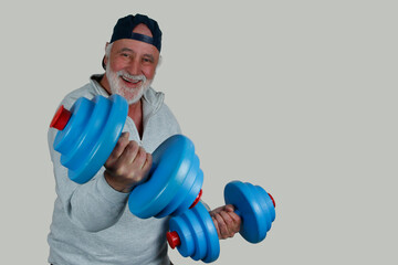 Strong at Any Age. An older man laughs while training with blue dumbbells. Strong and active, he lives his motto. Staying fit with age. Joy and movement go hand in hand.