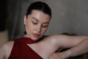 Beautiful pregnant woman in long red dress in sand. Big pregnant belly. Pretty brunette woman waiting child. Lady in room with chandeliers and portieres, fairy tale