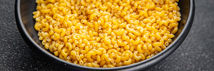 Macaroni pasta raw coquillette appetizer dish organic product fresh tasty gourmet food background on the table rustic food top view copy space