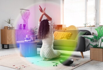 Young African-American woman meditating in room