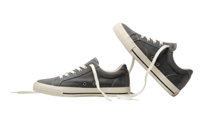 Grey sneakers featuring white laces resting on a transparent background, creating a stylish and minimalist footwear composition perfect for casual and athletic lifestyles