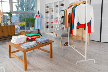 Interior of clothing shop with rack and table
