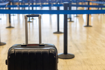 Black suitcase waiting in line at Punta Cana airport during busy travel season