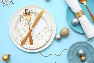 Beautiful table setting with Christmas balls on blue background