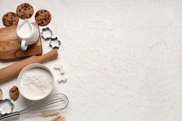 Composition with wooden rolling pin, kitchen utensils and ingredients for dough on white background
