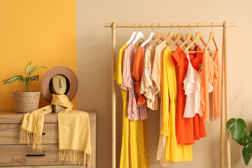 Stylish interior of modern dressing room with orange clothes