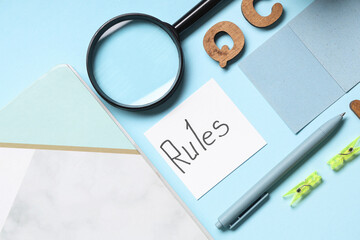 Paper with word RULES and stationery on blue background