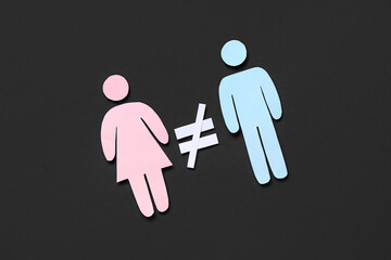 Female and male paper figures with crossed equal sign on black background