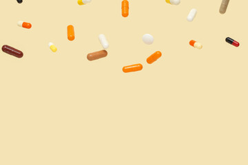 Flying colorful pills on yellow background