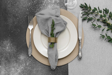 Beautiful table setting with eucalyptus branches on dark background
