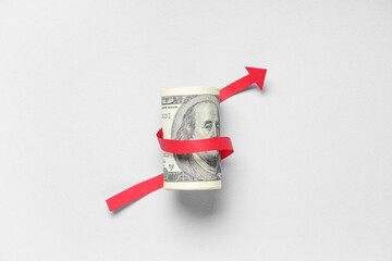 Dollar banknote with arrow on light background. Concept of rising price