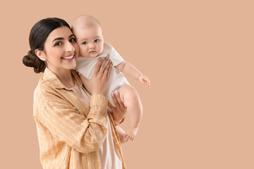 Happy mother with her little baby on beige background