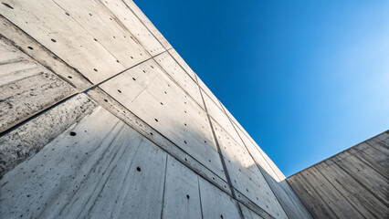 Unique Angle Shot of Concrete Wall Under Clear Blue Sky Barrier or obstacle