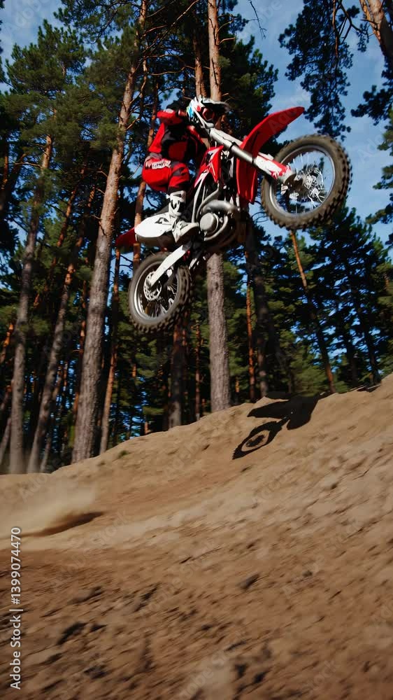 Poster dynamic low-angle shot of a motorcyclist speeding through a forest trail, capturing dust clouds and 
