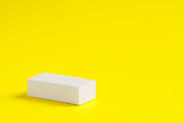 One eraser on yellow background, closeup. Space for text