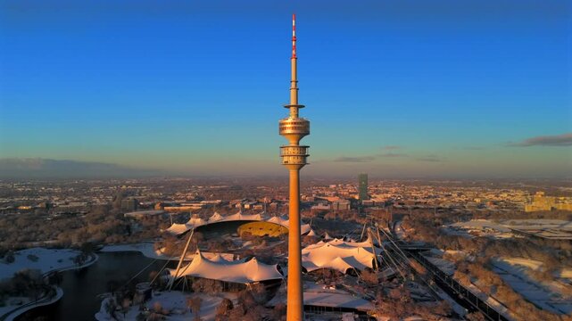 Olympiaturm Historische Sehenswurdigkeit im Olympiapark Munchen, Deutschland Luftaufnahme im Winter. Olympic Tower in Olympic Park, Munich, Germany aerial view in winter in snowy weather. Landmark. 