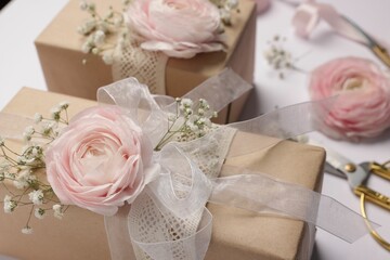 Florist. Boxes, flowers, ribbon and scissors on white background, closeup