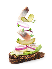 Tasty bruschetta with herring and flying ingredients on white background