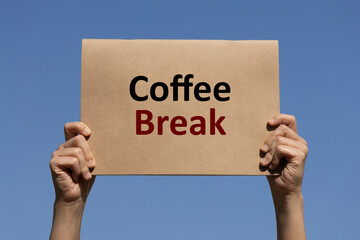 Coffee break text on brown paper holding by 2 hands of a man