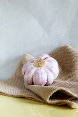 Garlic on the jute fabric in front  light gray wall.