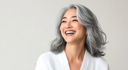 Obraz premium A radiant woman with flowing silver hair smiles joyfully, her expression filled with happiness and warmth.