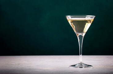 Italian white bianco vermouth in glass on dark green background