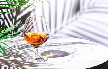 French cognac X.O. in glass on white background, hard light and shadows