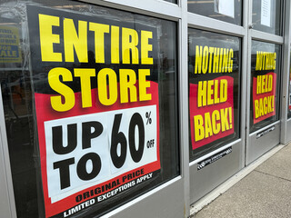 Retail store is going out of business with a large banner displaying store closing sale