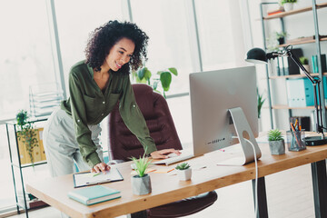 Young professional businesswoman working confidently in a modern office with natural lighting