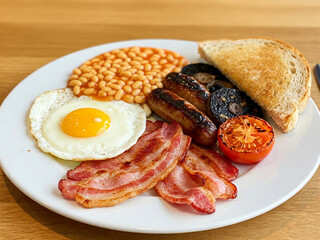 A classic Full English breakfast, beautifully arranged on a pristine white plate.