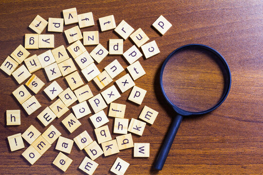 English letters scattered on wooden table surface. Idea to develop grammar thinking skills and English learning.