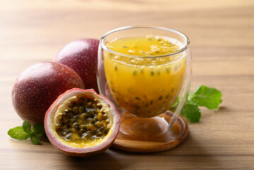 Glass of passion fruit juice with fresh passion fruit on wooden background, Healthy drink