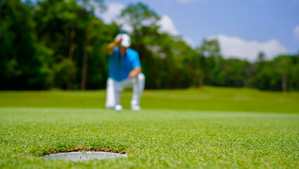 Golfer playing golf in the evening golf course, on sun set evening time.