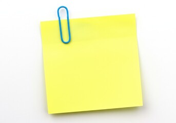 A yellow sticky note attached with a blue paper clip on a plain white background surface view top