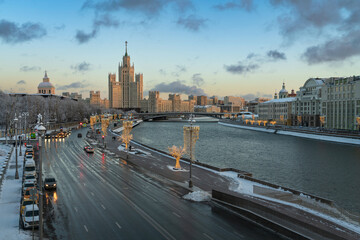 Obraz premium View of the Moskvoretskaya embankment of the Moskva River and the Stalin high-rise apartment building on Kotelnicheskaya Embankment with New Year decorations, Moscow, Russia
