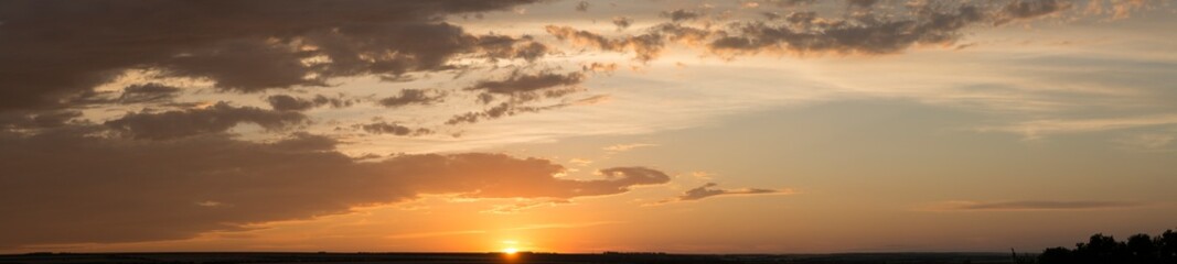 Landscape at sunset. Tragic gloomy sky. Panorama. Crimson twilight. Heavy, gloomy, dark clouds.